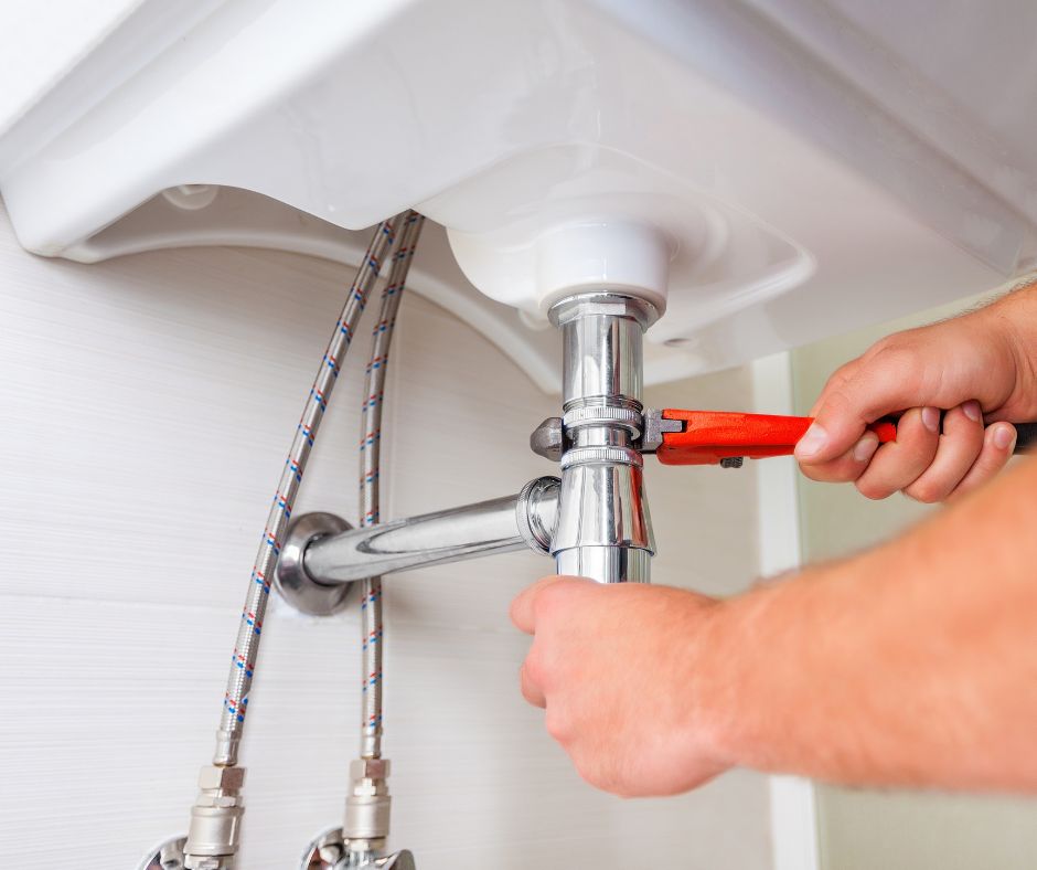 A plumber tightening a pipe